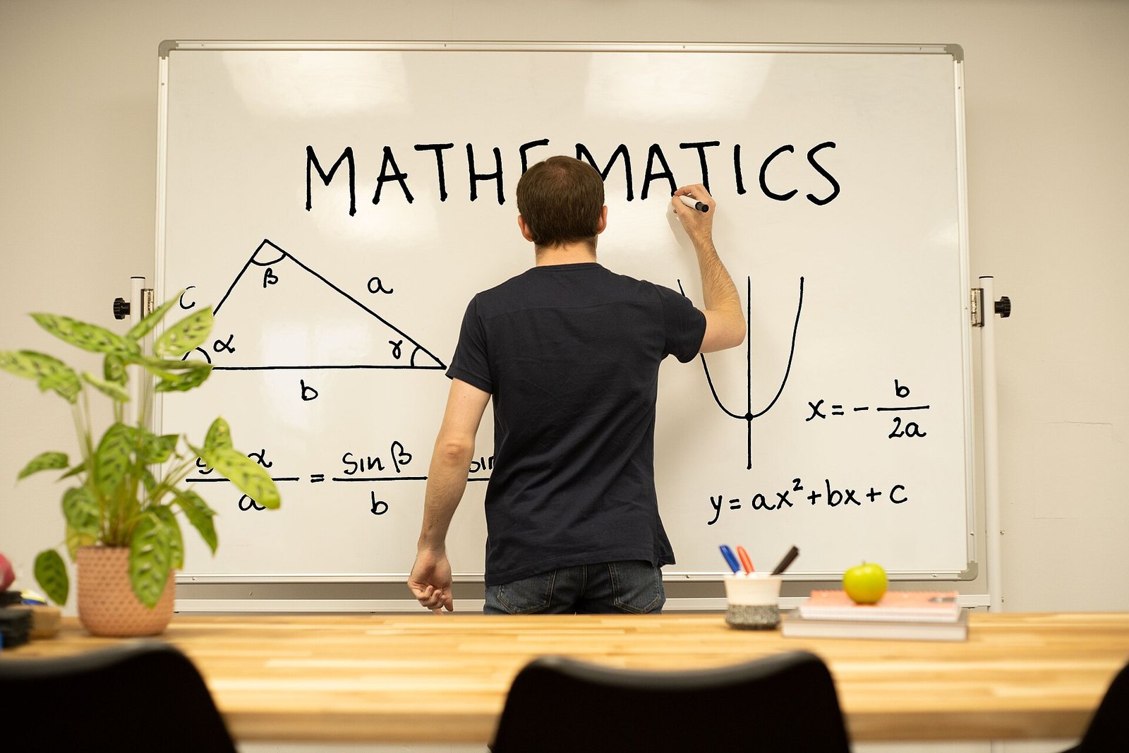 Tutor writing math formulas on a whiteboard